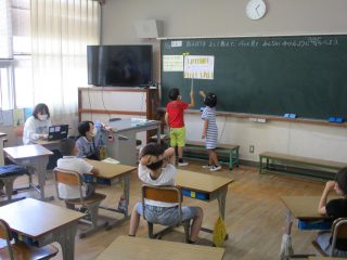 黒板の前に立つ二人の生徒